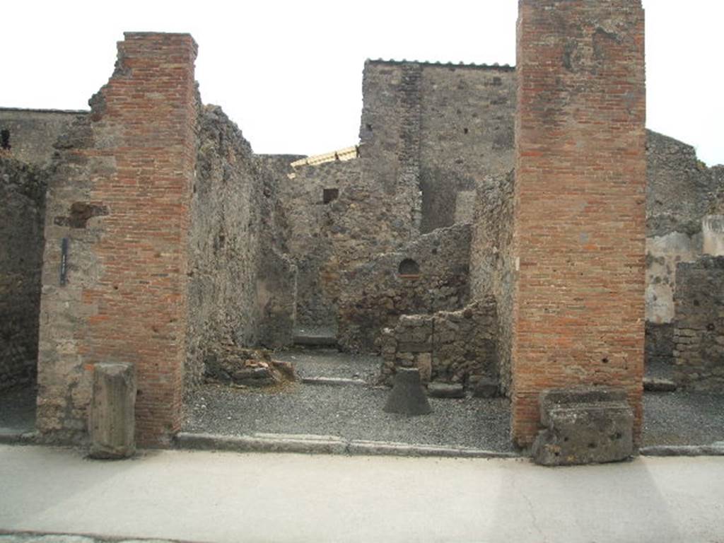 VI.8.15 Pompeii. May 2005. Entrance doorway, looking west across shop-room. On the left are the remains of the steps to the upper floor, on the south side of the doorway into the middle rear room. Graffito was found on the pilaster on the right, between 15 and 16 (see VI.8.16)