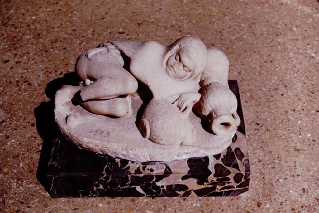 VI.8.23 Pompeii. 1964. White marble statuette of sleeping child clutching a basket.
According to Wilhelmina, the fish in the basket had its mouth bored for use as a fountain. Photo by Stanley A. Jashemski. Now in Naples Archaeological Museum, inventory number 6509.
Source: The Wilhelmina and Stanley A. Jashemski archive in the University of Maryland Library, Special Collections (See collection page) and made available under the Creative Commons Attribution-Non Commercial License v.4. See Licence and use details. J64f1773
See Jashemski, W. F., 1993. The Gardens of Pompeii, Volume II: Appendices. New York: Caratzas. (p.136)