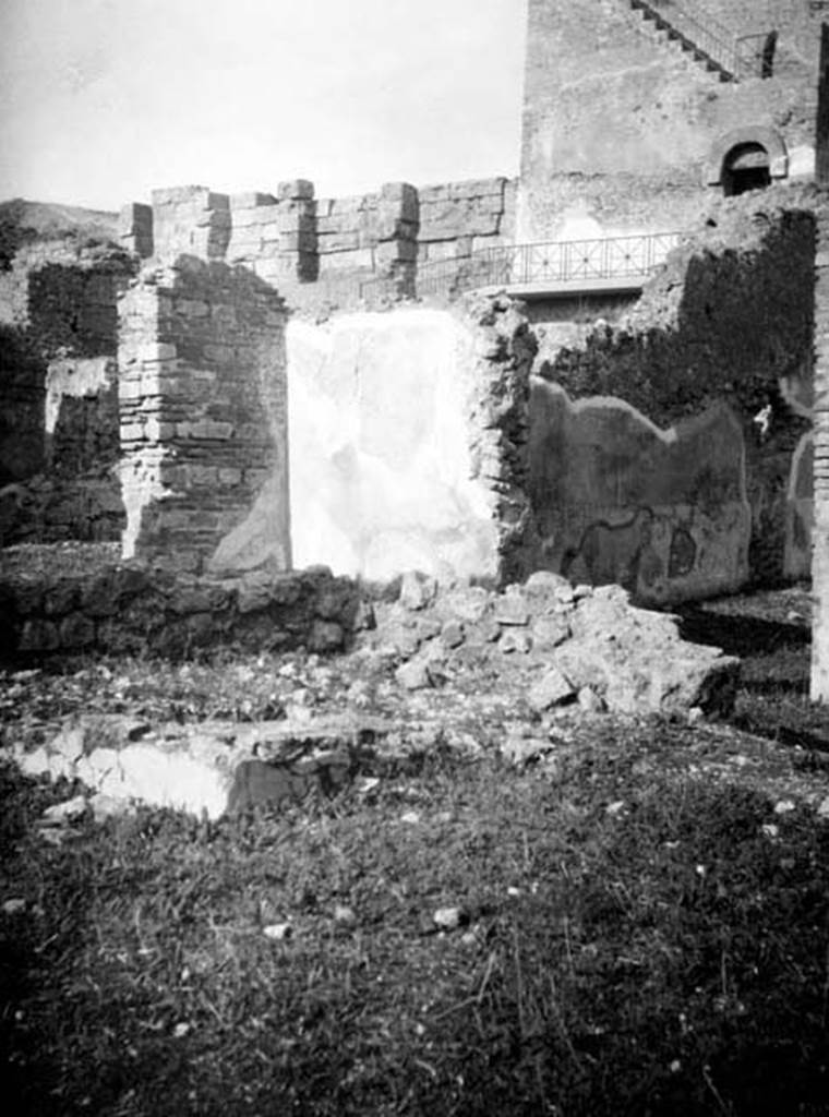 6.9.1 Pompeii. W660. Looking north-west across the walkway (room 4) on north side of garden 18. On the right, through the open doorway, are the remains of the west wall of room 11, the large oecus.
Photo by Tatiana Warscher. With kind permission of DAI Rome, whose copyright it remains.
See http://arachne.uni-koeln.de/item/marbilderbestand/231236
According to Warscher, this photograph showed the north-west corner of the Xystus where one could see the remains of a podium, the channel, and the mouth of the cistern.
In the background was the triclinium “L”.
See Warscher, T, 1938: Codex Topographicus Pompejanus, Regio VI, insula 9: Pars prima, (no.23), DAIR, Rome.