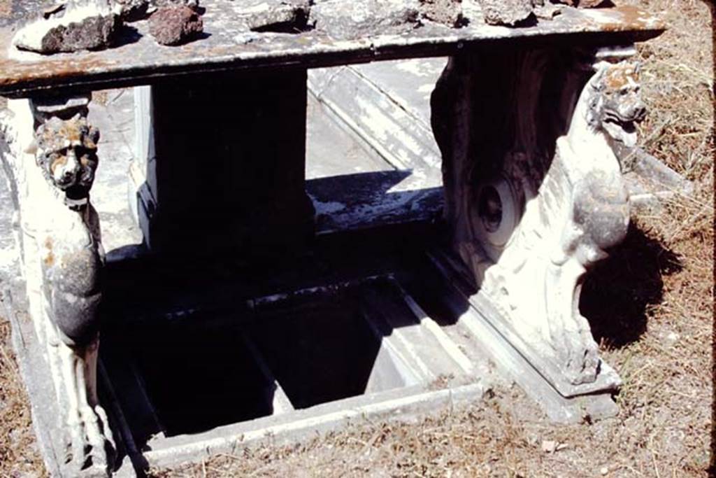 VI.9.2 Pompeii, 1968.
Room 2, looking west. Below the table was a small tub/basin with two compartments located between the table legs.
On the inside of both legs was a roundel with the bust of a cupid in the centre. Photo by Stanley A. Jashemski.
Source: The Wilhelmina and Stanley A. Jashemski archive in the University of Maryland Library, Special Collections (See collection page) and made available under the Creative Commons Attribution-Non-Commercial License v.4. See Licence and use details.
J68f1000
In the foreground under the table 6 are two square marble recesses 7. According to Overbeck and Mau these were for cooling bottles.
See Overbeck J., 1884. Pompeji in seinen Gebäuden, Alterthümen und Kunstwerken. Leipzig: Engelmann, p. 308.