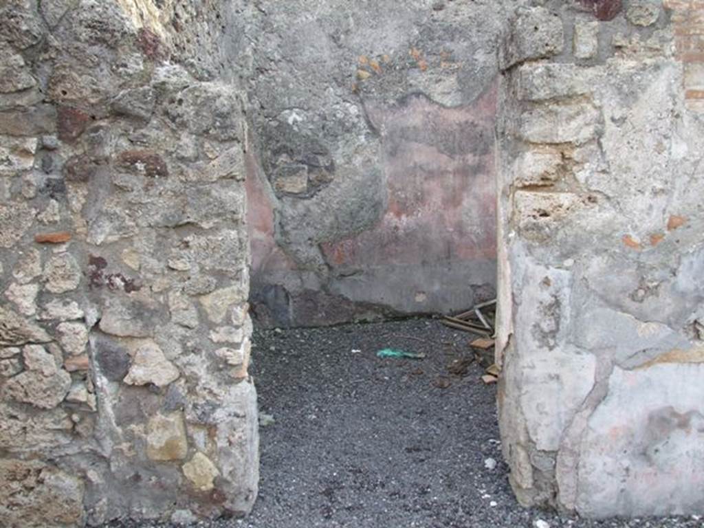VI.9.2 Pompeii. December 2007. Doorway to room 14, cubiculum on south side of atrium.
According to PPM, the walls were painted with a black zoccolo and a red middle zone with a glimpse of architectural decoration. The floor was of cocciopesto ornamented with white tesserae, which seemed to have been later modernised with the insertion of pieces of marble.