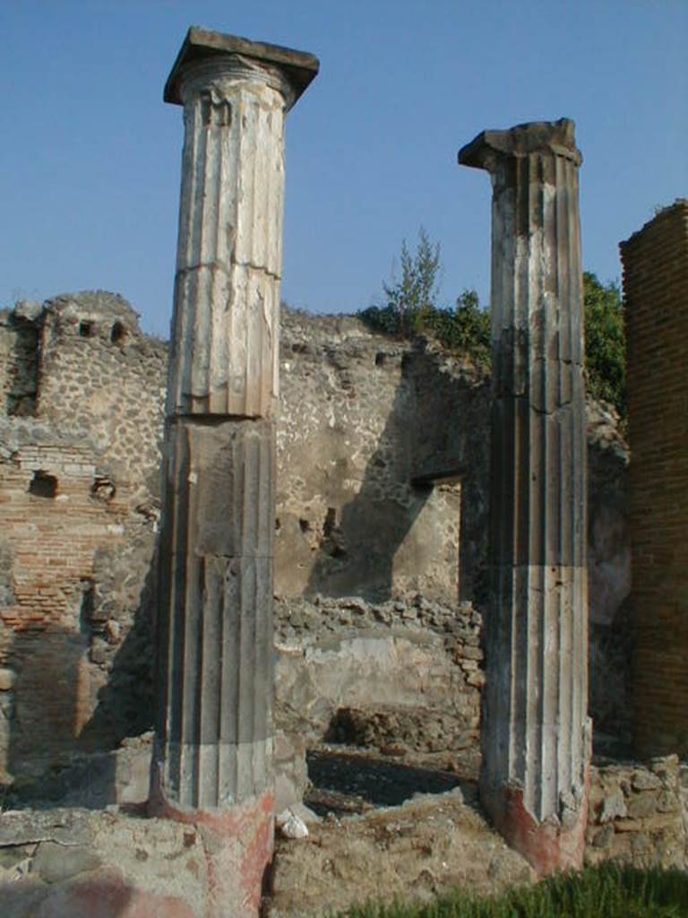 VI.9.3 Pompeii. September 2004. Columns on north side of pseudo-peristyle 9.The doorway to the kitchen can be seen on the right of centre.