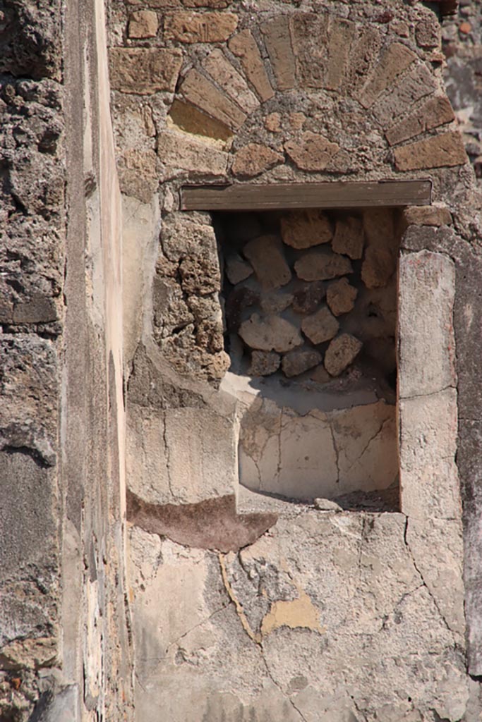 VI.9.5 Pompeii. October 2022.
Tablinum 26, east wall, niche on north side of doorway leading to area 29/30.
Photo courtesy of Klaus Heese.