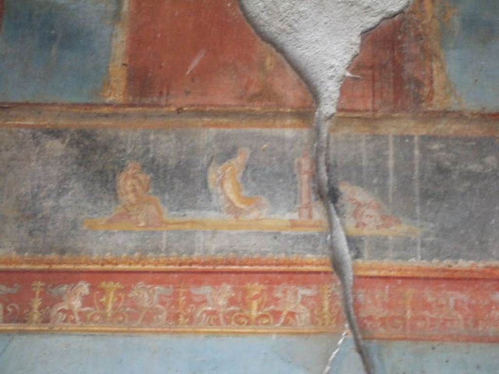 VI.9.6 Pompeii. May 2006. Room 8, border with griffins and painted scene with three figures, from the upper west end of the north wall.