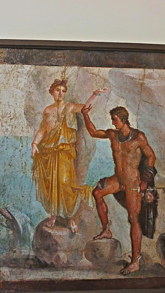 VI.9.6 Pompeii. Wall painting of Perseus rescuing Andromeda.
According to the information card –
“Perseus and Andromeda: this is the largest version of a subject found many times in the decoration of the Vesuvian cities.
The hero helps the young girl to climb down the rock to which she had been chained.
He holds a sword in his left hand and the recently severed head of the Gorgon.”
Now in Naples Archaeological Museum. Inventory number 8998.
Photo courtesy of Giuseppe Ciaramella, November 2018.