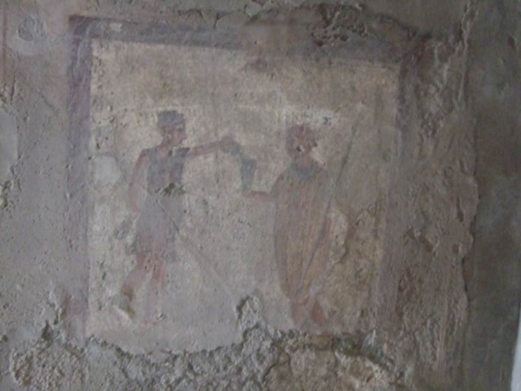 VI.10.1 Pompeii. March 2009. Fresco on north wall of rear room on north side. A soldier with spear in his left hand holds out his cup to a slave.
“Da fridam pusillum” (CIL IV 1291) has been inscribed on the picture.
According to Cooley, this graffiti has been written above the people’s head, as if they are speaking. She says this showed a soldier being served wine by a slave and he was saying “Give a drop of cold”. See Cooley, A. and M.G.L., 2004. Pompeii : A Sourcebook. London : Routledge. (p.162, CIL IV 1291)