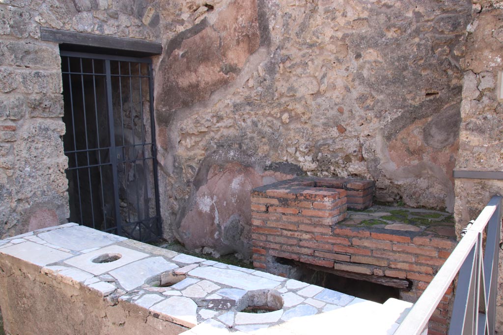 VI.10.1 Pompeii. October 2022.
Looking towards south wall of bar-room with hearth and doorway to rear room on south side of bar-room. Photo courtesy of Klaus Heese.