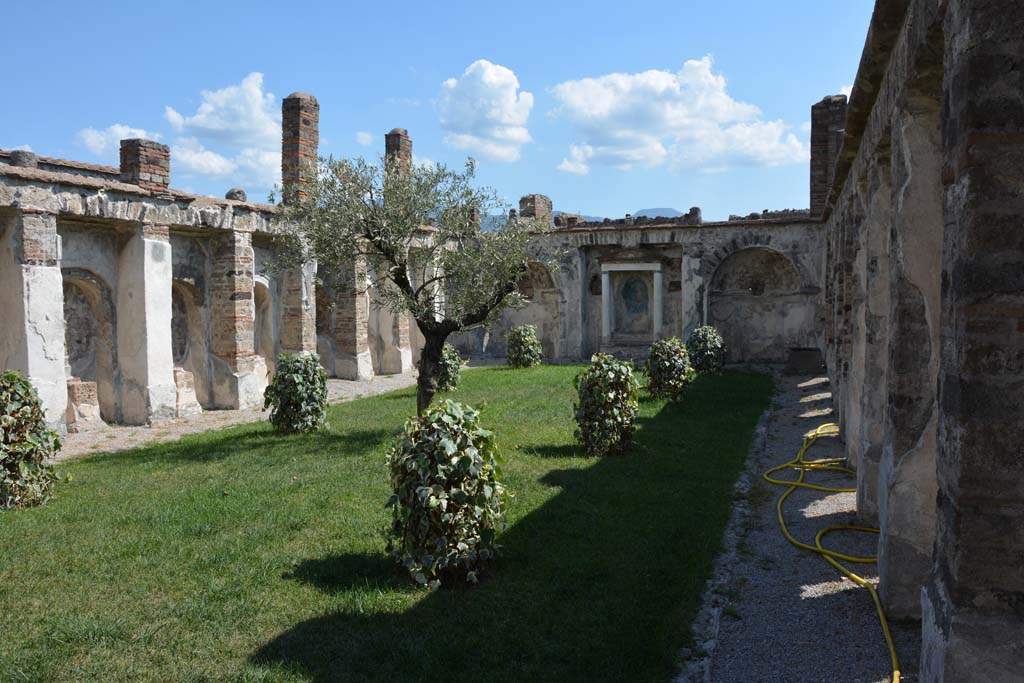 VI.10.7 Pompeii. September 2019. Looking south from north end.
Foto Annette Haug, ERC Grant 681269 DÉCOR.
According to the PAP information card in this house –
“The garden area is enclosed on three sides by a cryptoporticus (covered corridor).
In one of the phases in which the house was built, the short side at the end of the garden was embellished with an aedicula (tabernacle) flanked by two fountains and niches set between the arches of the cryptoporticus.
The three rooms opening onto the upper terrace at the north end had the benefit of the view of this splendid porticoed viridarium with its aedicula.”