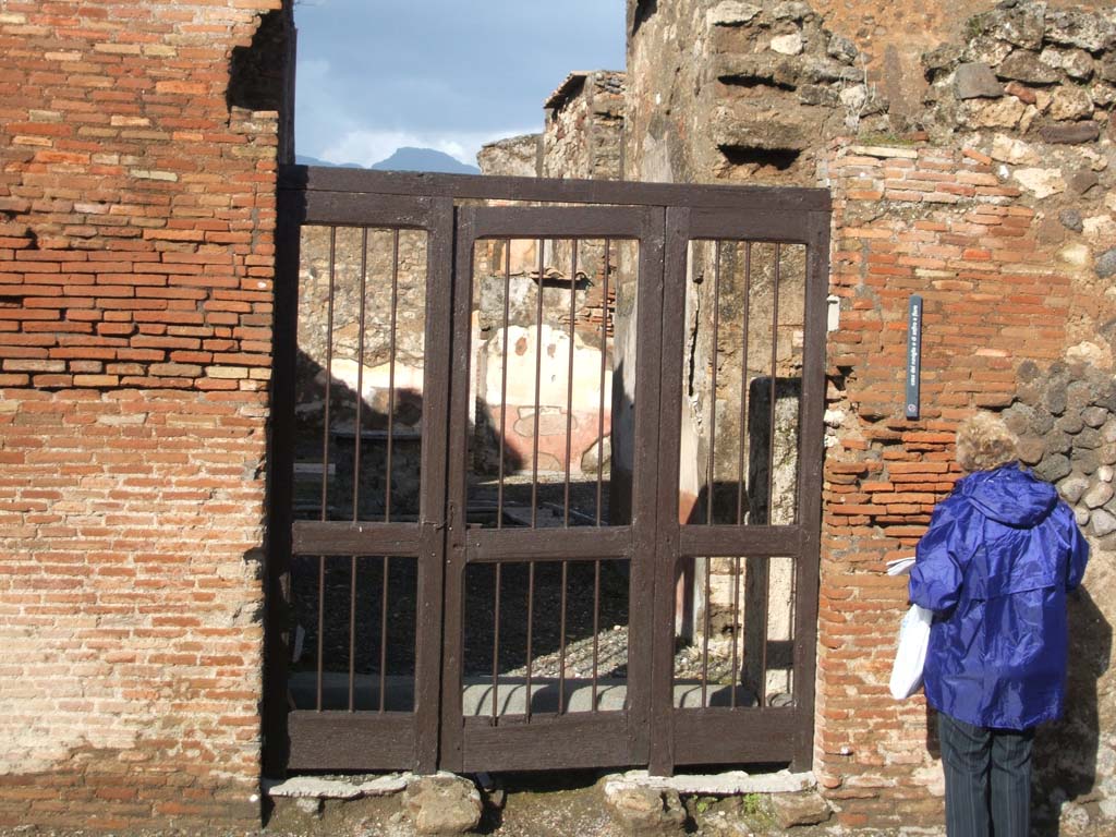 VI.10.11 Pompeii. December 2004. Entrance doorway, with lava threshold.
According to Pagano and Prisciandaro, found in January 1827 on the west (left) side of the entrance doorway, was –

M(arcum) Cerrinium
Vatiam aed(ilem)
Tintirius rog(at)    [CIL IV 156]

See Pagano, M. and Prisciandaro, R., 2006. Studio sulle provenienze degli oggetti rinvenuti negli scavi borbonici del regno di Napoli. Naples: Nicola Longobardi. 
(p.136)  PAH II, 183. 

According to Fröhlich, also seen on the left pilaster was a painting of a figure, possibly a Lar.
Below were two serpents flanking an altar. All the paintings have now faded and disappeared.
See Fröhlich, T., 1991. Lararien und Fassadenbilder in den Vesuvstädten. Mainz: von Zabern. (F40)
See Helbig, W., 1868. Wandgemälde der vom Vesuv verschütteten Städte Campaniens. Leipzig: Breitkopf und Härtel. (86)
