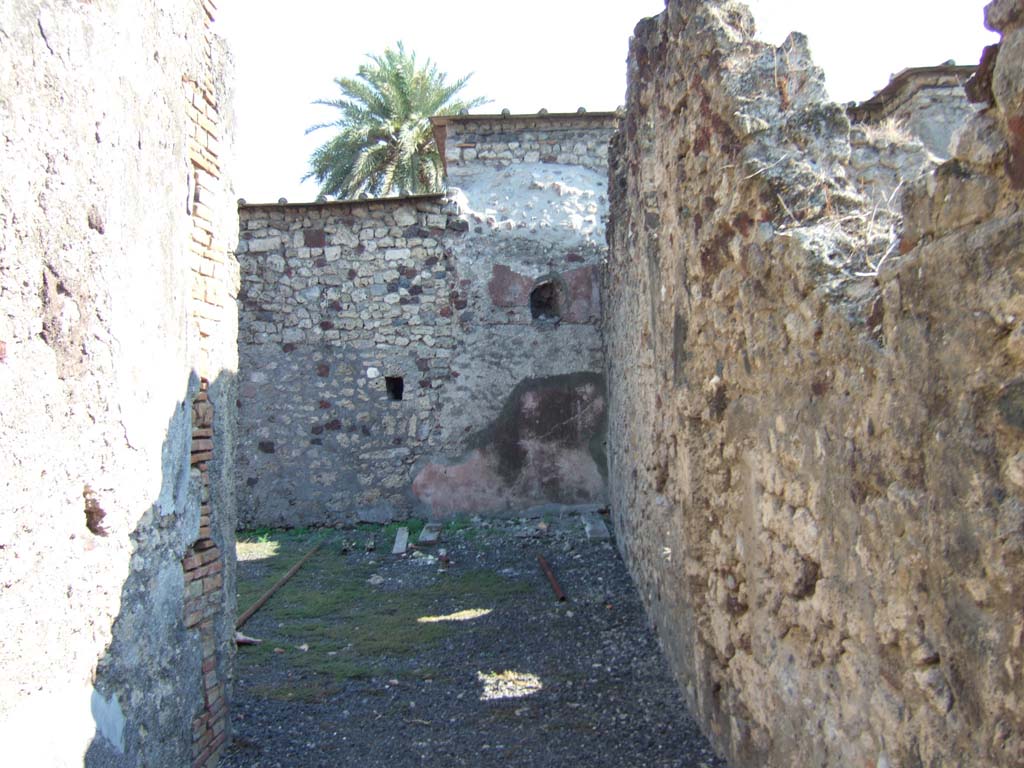 VI.11.12 Pompeii. September 2005.
Looking south along unroofed walkway (19) towards south-west corner of garden area (7), along wide corridor of walkway.
The wall on the south side would join to VI.11.10 and the wall on the west (right) would join to VI.11.8.
According to Garcia y Garcia –
the same bomb that destroyed VI.11.8 also caused the destruction of several rustic rooms in the south of house VI.11.12.
These would have had their dividing walls to the south with VI.11.10, and to the west with VI.11.8.
In the 1980s he said, all the fallen structures were in total ruin and abandoned.
See Garcia y Garcia, L., 2006. Danni di guerra a Pompei. Rome: L’Erma di Bretschneider. (p.82).