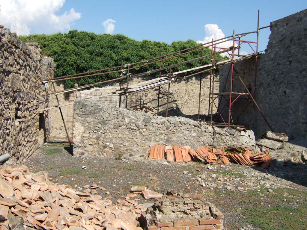 VI.11.11/12 Pompeii. September 2005. Looking east from garden area (7) towards entrance, on left.
Under the scaffolding, on the right, may have been the workshop, with kitchen, latrine and dormitory?
See Eschebach, L., 1993. Gebäudeverzeichnis und Stadtplan der antiken Stadt Pompeji. Köln: Böhlau. (p.200).