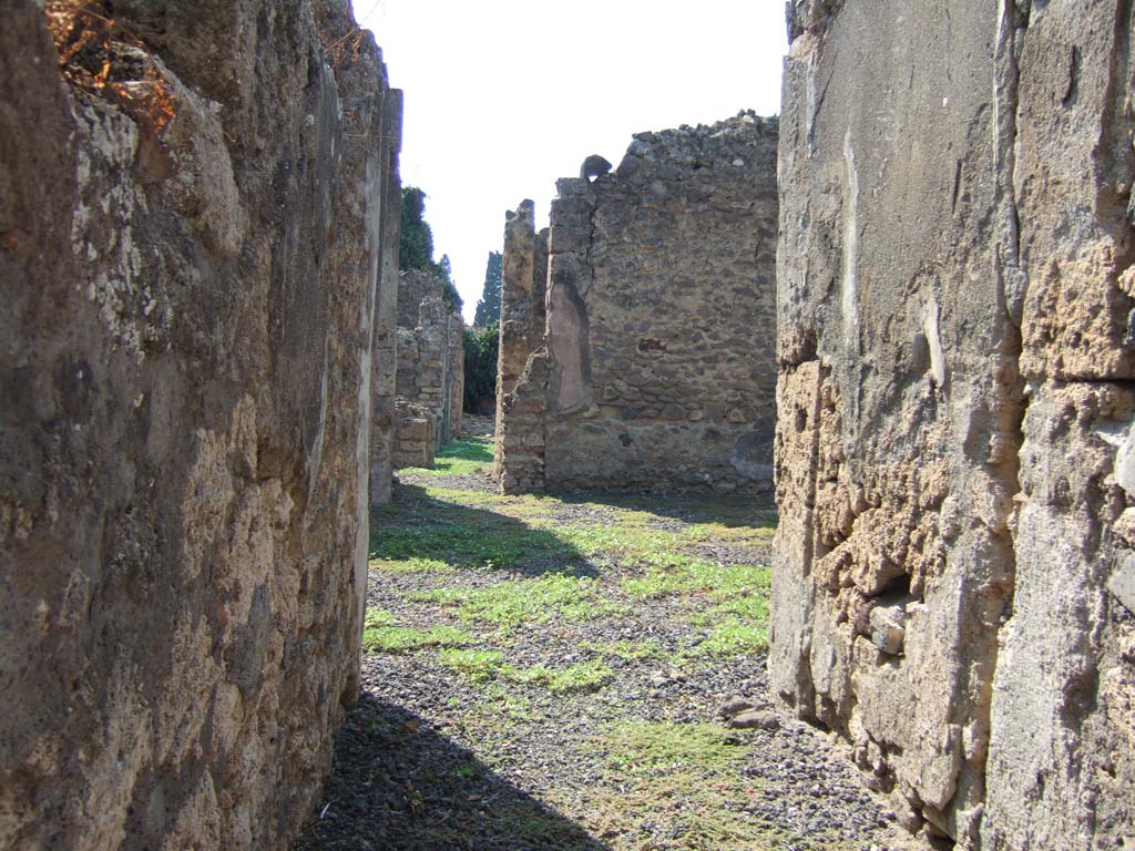 VI.11.13 Pompeii. September 2005. Looking west towards atrium, from entrance corridor.
According to Jashemski, a passageway in this house (excavated in 1842) led from the atrium to an open area on the right in which there was a cistern head.
Such an area would normally be a garden but, since Fiorelli on the basis of numerous graffiti identified this site as the home and workshop of a producer of sailors clothing, the garden may have been used for other purposes.
See Jashemski, W. F., 1993. The Gardens of Pompeii, Volume II: Appendices. New York: Caratzas. (p.144)
For list of graffiti, see below.