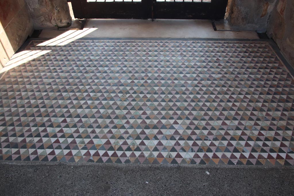VI.12.2 Pompeii. October 2022. Entrance corridor/fauces, looking south from interior.
The flooring is made of small triangular pieces of marble and slate – red, yellow, green, white and black. Photo courtesy of Klaus Heese.