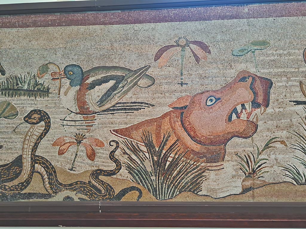 VI.12.2 Pompeii. September 2024.
Detail from mosaic of Nilotic scene, including ducks, cobra and hippopotamus. Photo courtesy of Giuseppe Ciaramella.
