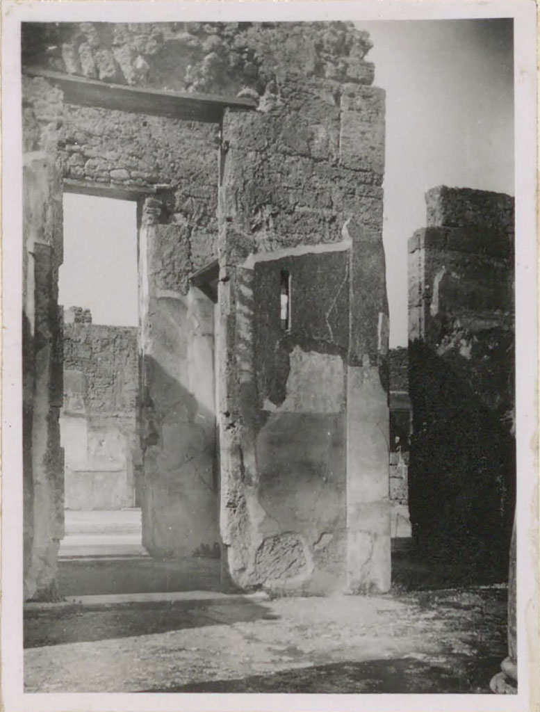 VI.12.5 Pompeii. Pre-1943. West side of tetrastyle atrium 7. (On the right is the west ala 11.)
Looking west from Tetrastyle atrium towards doorway of room 10 that also served as a passageway between the two atriums.
In this room, there was a rare example of a perfectly preserved interior window with a piece of glass.
(In camera che serviva di passaggio fra i due atri, (attraversa la seconda porta si vede la parete del cubicolo no.17 – sul lato occidentale dell’atrio toscanico) – vi era un raro sempio di una finestra interna perfettamente conservata con un pezzo di vetro.)
See Warscher, T. (1946). Casa del Fauno, Swedish Institute, Rome. (p.58, n.83).
According to Garcia y Garcia, in his description of fig. 162 on p.84, same photo as above -he says –
“Atrio tetrastilo, lato occidentale prima del bombardamento: la finestrella a destra dell’ingresso era dotato da vetro al momento dello scavo.”(Foto T. Warscher).
(“Tetrastyle atrium, west side before the 1943 bombing: the small window on the right of the entrance was equipped with glass at the time of excavation”.)
See Garcia y Garcia, L., 2006. Danni di guerra a Pompei. Rome: L’Erma di Bretschneider. (p.84, fig.162).