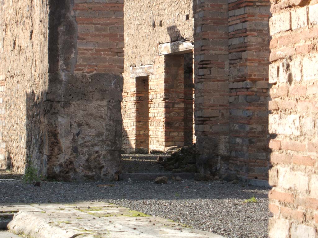 VI.13.13 Pompeii. December 2004.
North-west corner of atrium, with doorway to oecus containing a corridor to the rear rooms.
The doorways to the kitchen and latrine, and a storeroom can be seen.