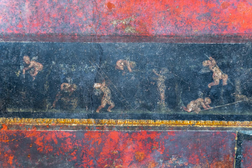 VI.15.1 Pompeii. March 2023.
Predella in centre of north wall painted panel of cupids gathering and pressing grapes. Photo courtesy of Johannes Eber.