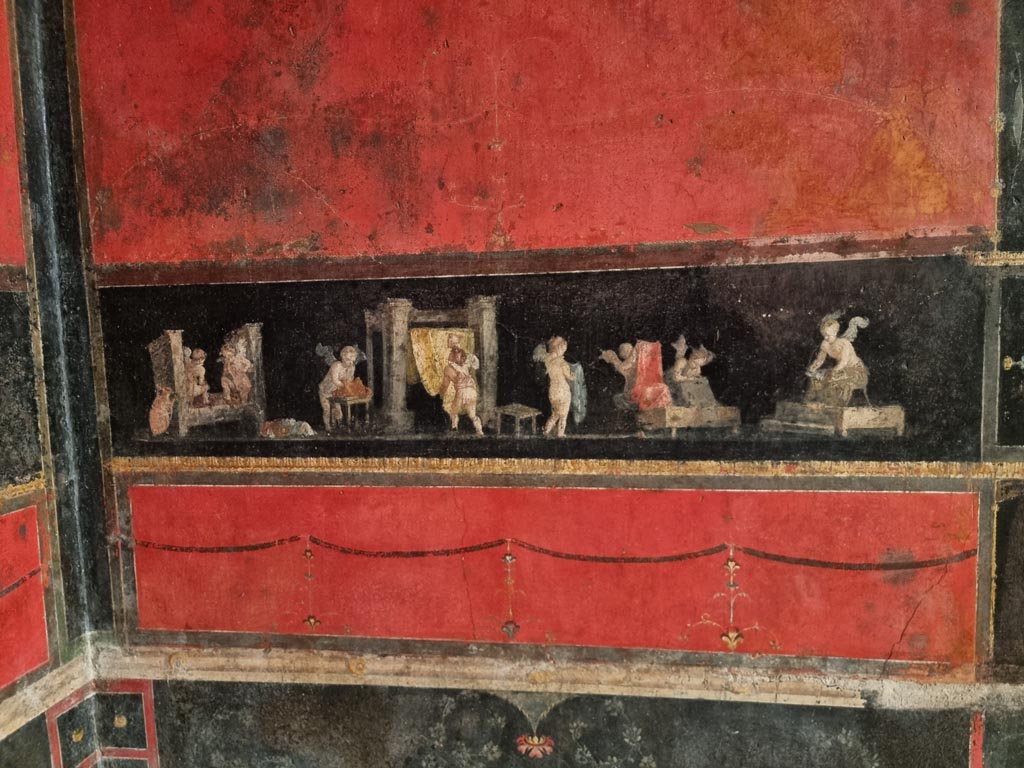 VI.15.1 Pompeii. December 2023.
Detail from panel on east wall in north-east corner with panel showing cupids cleaning clothes in a fullery. Photo courtesy of Miriam Colomer.