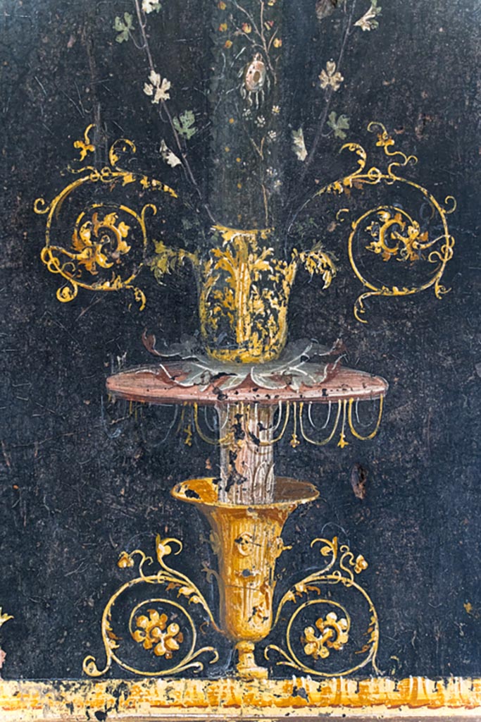 VI.15.1 Pompeii. August 2023.
Detail of base of painted candelabra on east wall at north end. Photo courtesy of Johannes Eber.
