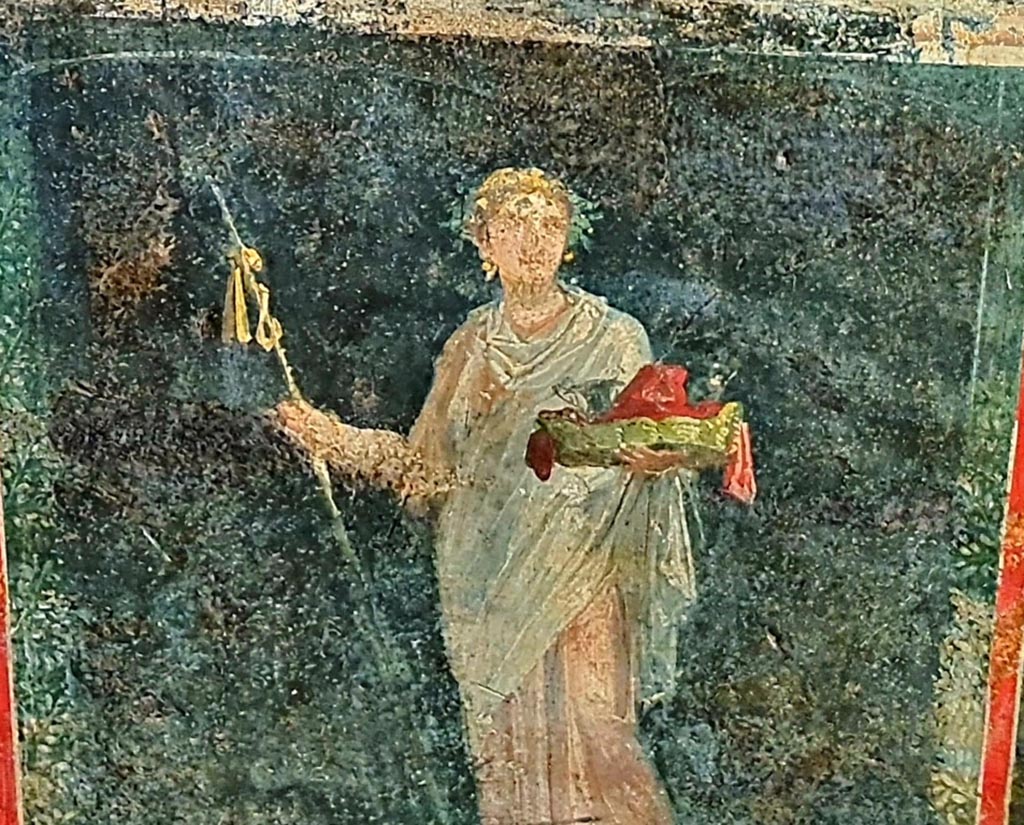 VI.15.1 Pompeii. April 2023.
Detail of painted female figure or priestess holding implements of sacrifice, from lower east wall (zoccolo) at north end.
Photo courtesy of Giuseppe Ciaramella.