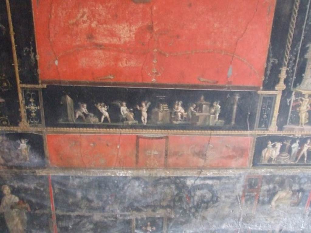 VI.15.1 Pompeii. December 2006. Room of the Cupids or Cherubs.
Painting of Cupid Goldsmiths. Below left is a female figure or priestess holding an implement of sacrifice. Below right are the remains of a painting of an Amazon with a shield.