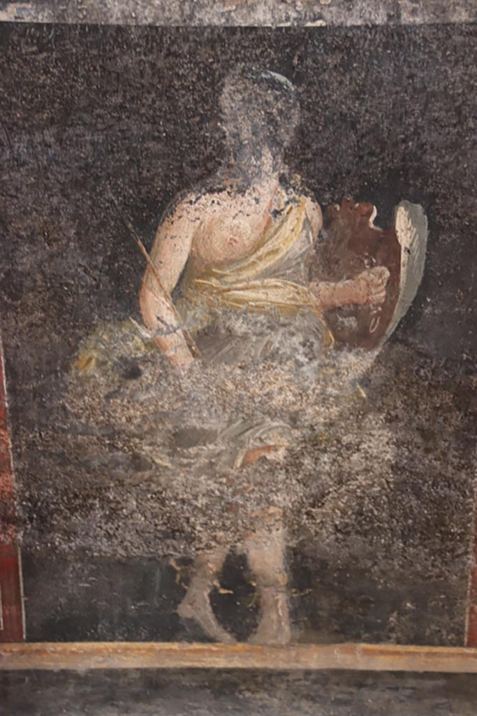 VI.15.1 Pompeii. October 2023.
Zoccolo on lower east wall on north side of central panel, figure of an Amazon armed with a shield.
Photo courtesy of Klaus Heese.