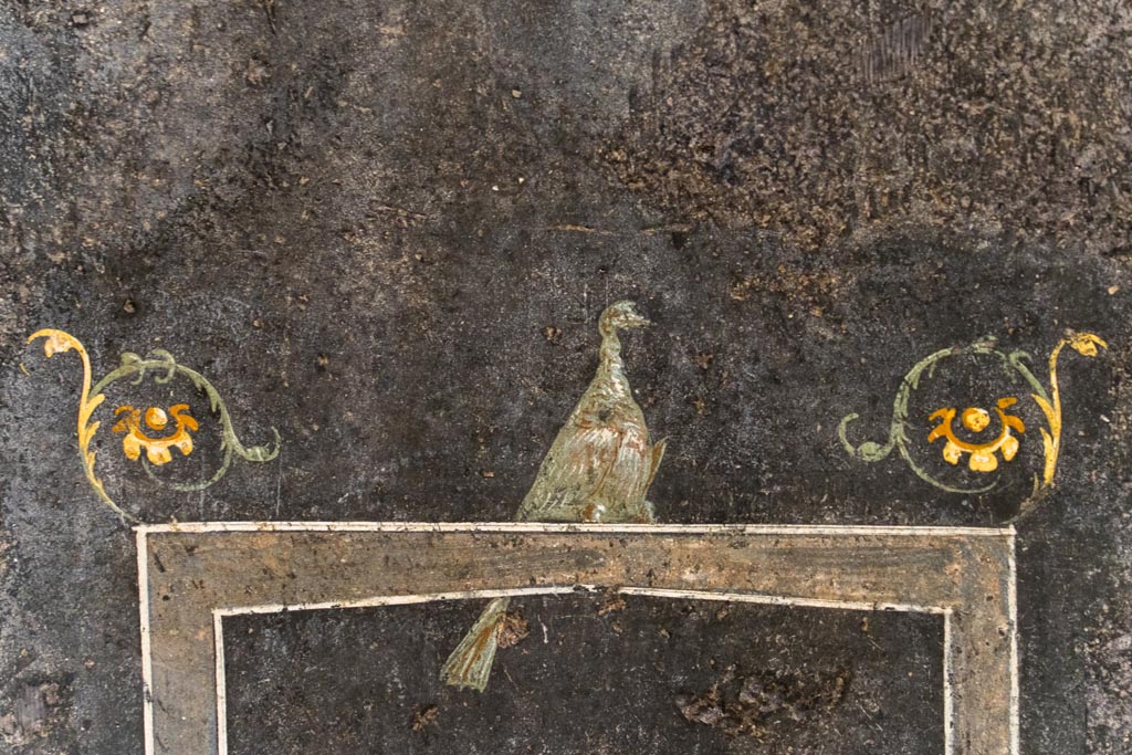 VI.15.1 Pompeii. August 2023.
Detail of painted bird on black painted zoccolo on lower east wall at south end. Photo courtesy of Johannes Eber.