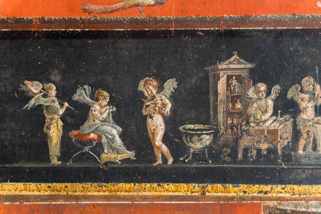 VI.15.1 Pompeii. March 2023.
Lower east wall at south end, part of painted panel of cupids making perfumed oil. Photo courtesy of Johannes Eber.