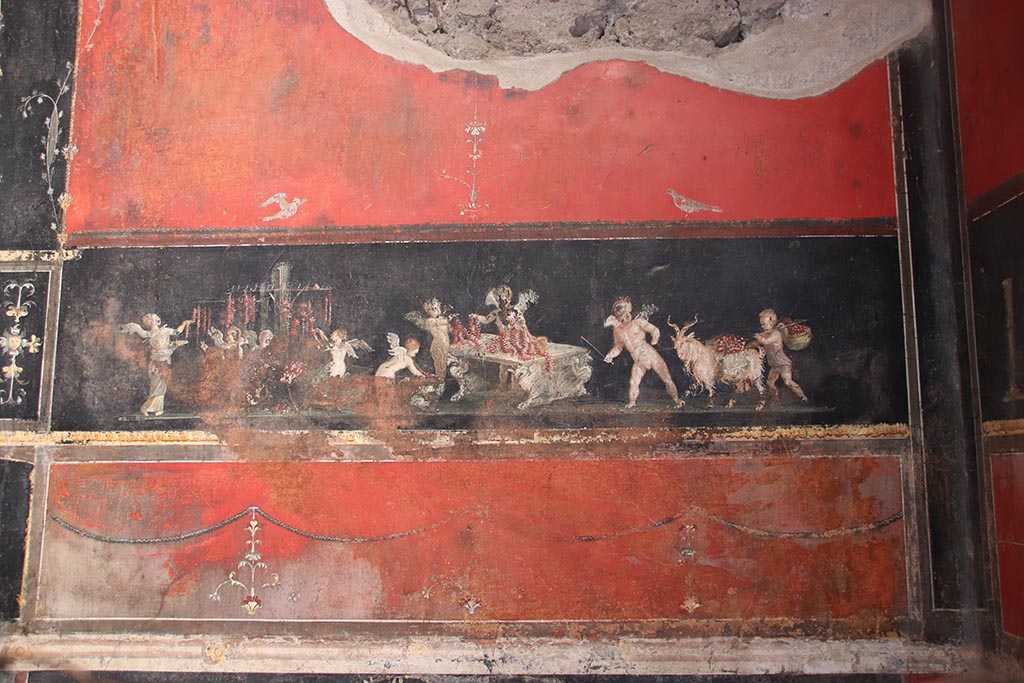 VI.15.1 Pompeii. October 2024.
East wall in the south-east corner with painting of cupids as flower dealers, picking and selling flowers and making garlands.
Photo courtesy of Klaus Heese