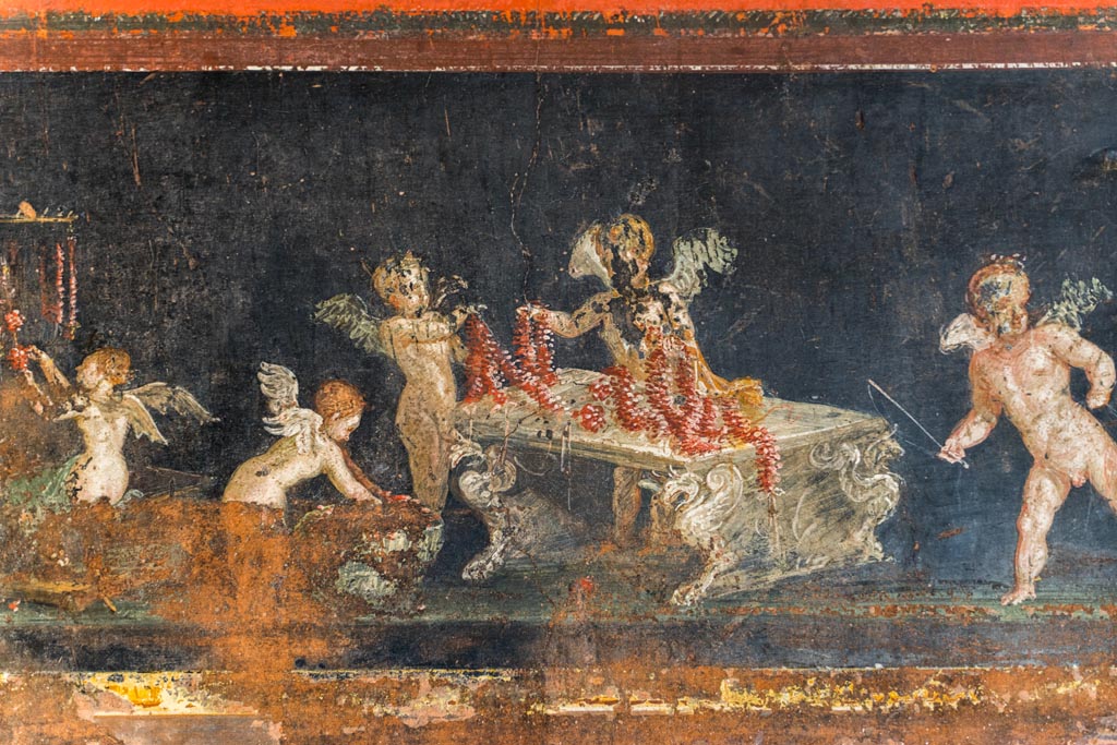 VI.15.1 Pompeii. March 2023.
East wall in the south-east corner, part of painted panel of cupids as flower dealers, picking and selling flowers and making garlands.
Photo courtesy of Johannes Eber.