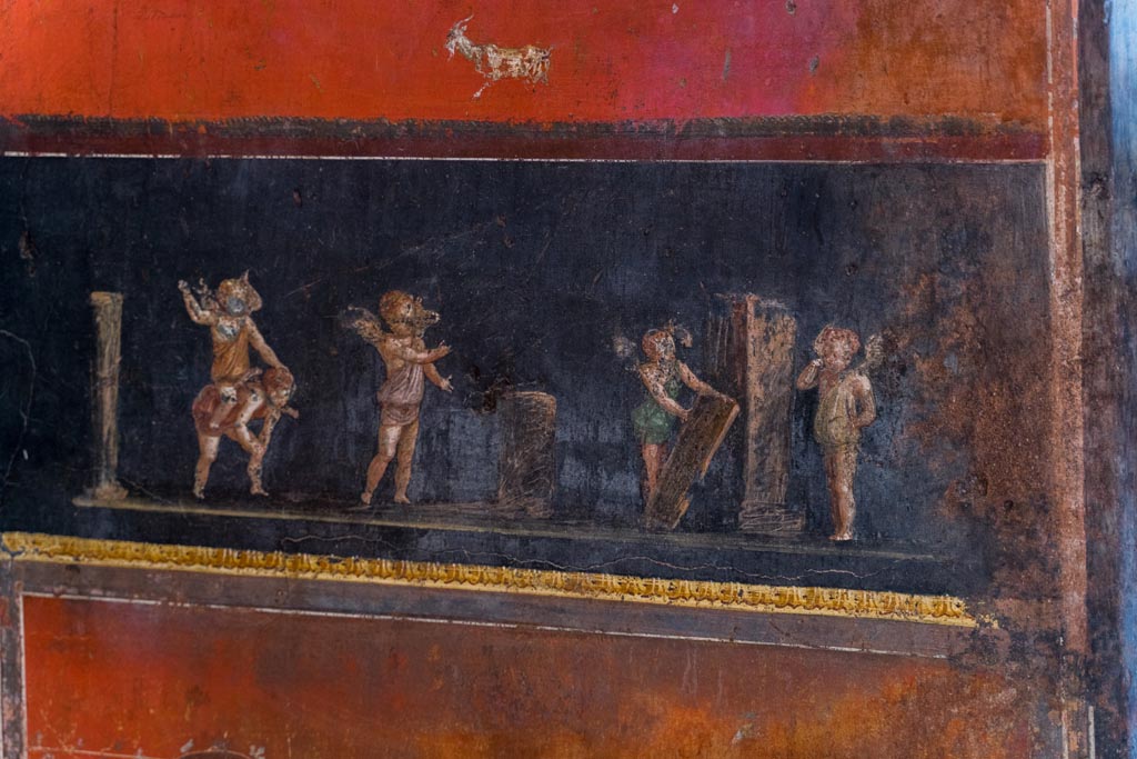 VI.15.1 Pompeii. March 2023.
South wall in south-east corner with painting of cupids taking part in an archery or throwing contest. Photo courtesy of Johannes Eber.
