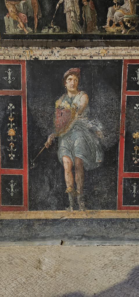 VI.15.1 Pompeii. December 2023.
Zoccolo on lower west wall on south side of central panel with Amazon holding axe and shield.
Photo courtesy of Miriam Colomer.