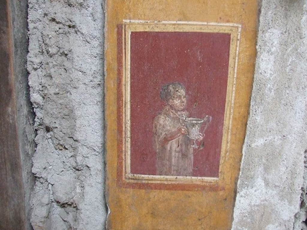 VI.15.1 Pompeii. December 2006. Detail of painted pillar between Peristyle and Atrium with figure holding a cup.