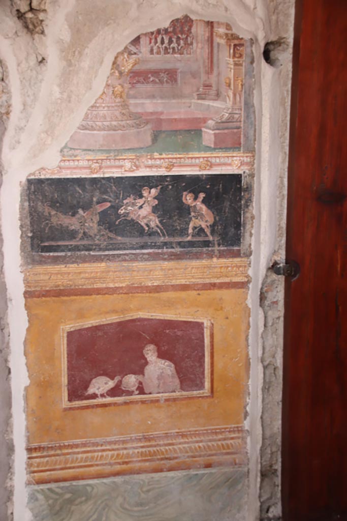 VI.15.1 Pompeii. October 2023.
East wall of atrium, detail from panel between cubiculum (d) on left, and into oecus (e), on right.
Photo courtesy of Klaus Heese.