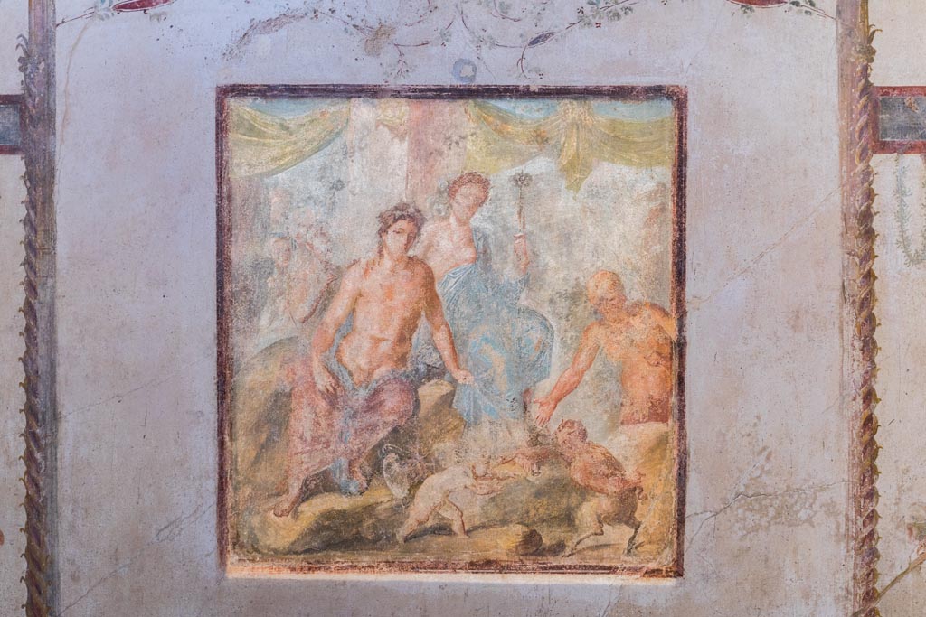 VI.15.1 Pompeii. March 2023. 
Central wall painting on south wall showing Dionysus and Ariadne, as well as the fight between Eros and Pan.
Photo courtesy of Johannes Eber.
Kuivalainen comments –
“A young half-naked Bacchus in the company of Ariadne, watching the fight about to begin, and Silenus already preparing to reward the victor with the palm leaf. The female figure’s dignified appearance suits Ariadne more than a maenad. His identification is also supported by her embracing arm. This motif of a fight between a cupid and a faun appears elsewhere as well; a good example is an outdoor scene from Herculaneum.” (MANN 9262).
See Kuivalainen, I., 2021. The Portrayal of Pompeian Bacchus. Commentationes Humanarum Litterarum 140. Helsinki: Finnish Society of Sciences and Letters, (p.133-35, D13).
