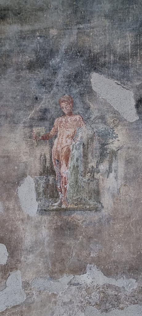 VI.15.1 Pompeii. January 2023.
Painting of a young nude Satyr with pan-pipes held in his right hand, and thyrsus in his left, from west wall of peristyle.
Photo courtesy of Miriam Colomer.