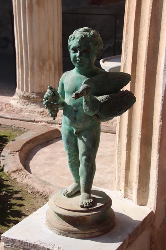 VI.15.1 Pompeii. October 2023.
Bronze statuette of boy with grapes and a goose/duck. Photo courtesy of Klaus Heese.