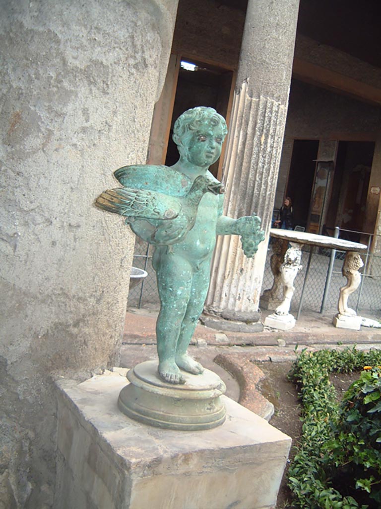 VI.15.1 Pompeii. North side of peristyle, looking east.
Bronze garden fountain statuette of boy, bird and grapes, May 2001.
Photograph courtesy of Current Archaeology.