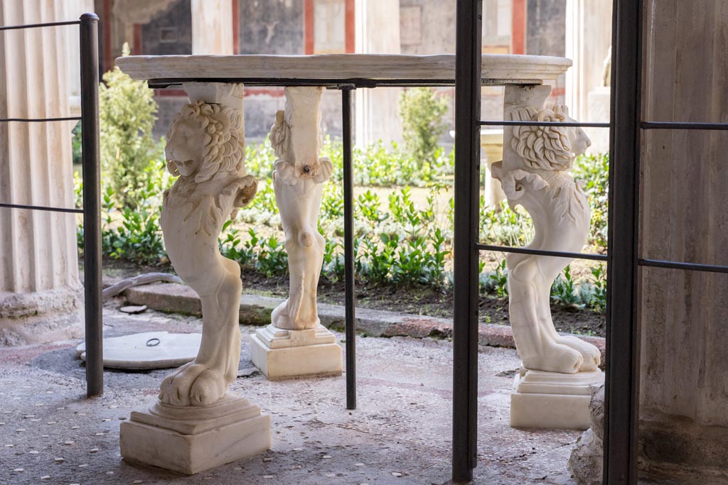 VI.15.1 Pompeii. March 2023.
Table with three lion legs in peristyle, looking south-west from east portico. Photo courtesy of Johannes Eber.