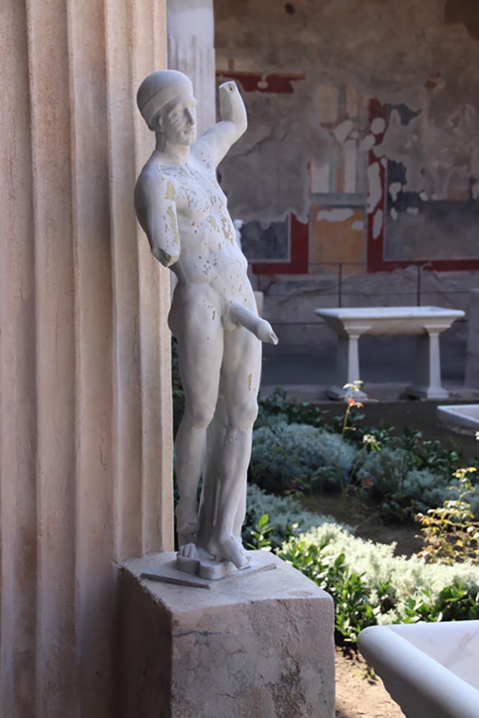 VI.15.1 Pompeii. October 2023.
Reproduction of marble Priapos on display in peristyle, but found near kitchen area.
Photo courtesy of Klaus Heese.