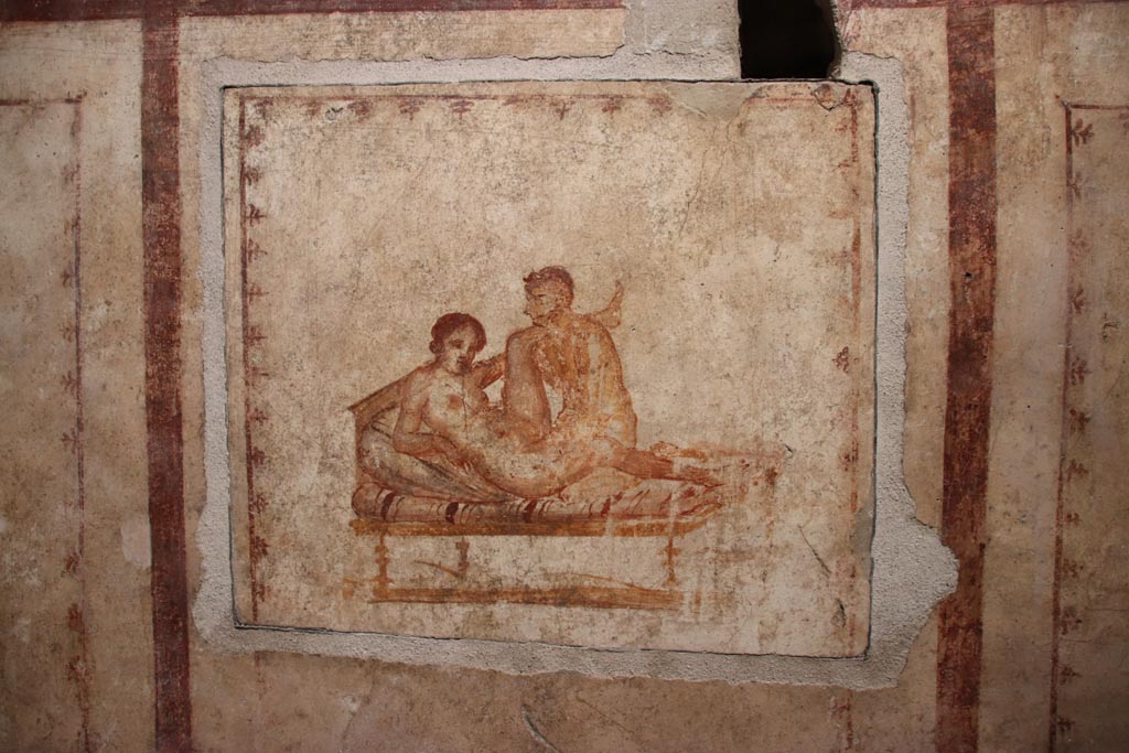 VI.15.1 Pompeii. October 2023.
Erotic painting on east wall in bedroom (x’), used either by servants or as a private brothel? Photo courtesy of Klaus Heese.