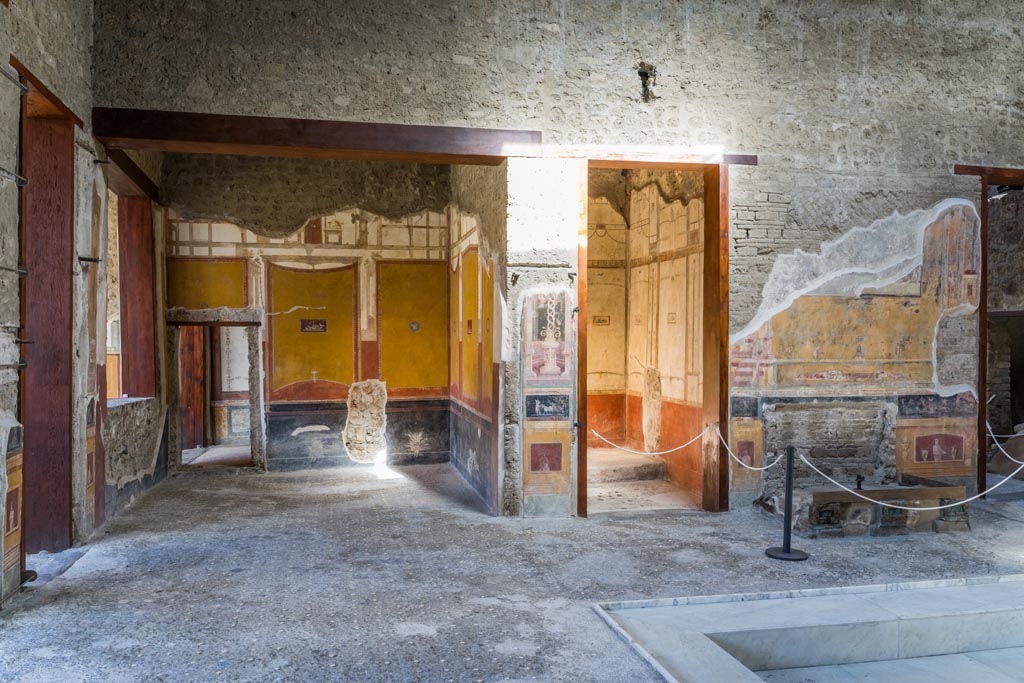 VI.15.1 Pompeii. March 2023.
Looking north across west end of atrium from south ala h, towards north ala i, on left. Photo courtesy of Johannes Eber.