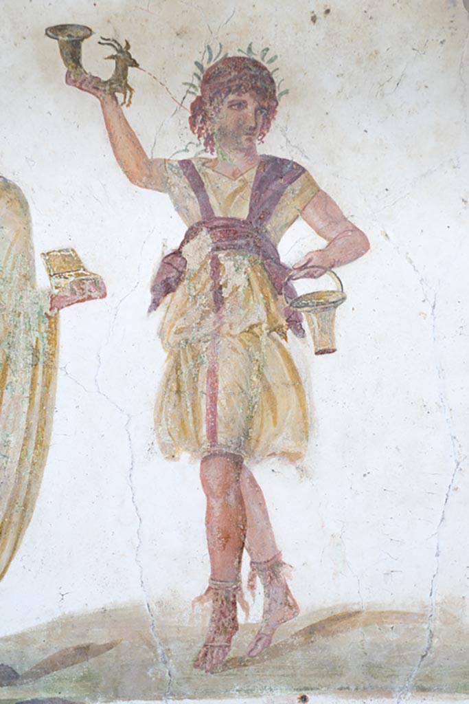 VI.15.1 Pompeii. March 2023.
Detail of wreathed Lar holding rhyton and situla, from north end of lararium painting.
Photo courtesy of Johannes Eber.
