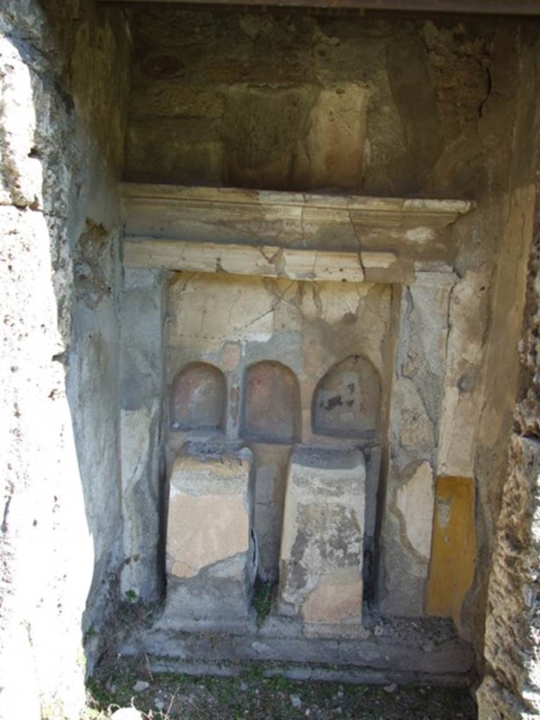 VI.15.5 Pompeii. March 2009. Room 1, atrium. Altar on east wall of the atrium composed of three arched niches, all of different sizes, and all three painted in red on the inside. In front of the niches are two brick altars, with the remains of painted plaster. According to Boyce, in the east wall of the atrium to the right of the entrance is a small recess done in the period of the First Style. It was evidently converted into a domestic sacellum at some later time. The back wall of the recess contains a large rectangular niche. This extends across almost its entire breadth, bordered by two pilasters. Later, it may have been in the time of the Second, or as late as the Fourth Style, three small irregular arched niches were cut, none of the same size. On the floor between them were set two masonry altars. The interior walls of the niches were coated with red, the altars with yellow stucco in imitation of marble.
There is still another niche of irregular shape in the wall above the First Style cornice of the original niche. See Boyce G. K., 1937. Corpus of the Lararia of Pompeii. Rome: MAAR 14. (p. 54-5, no.212, with Pl. 40, 1)
See Giacobello, F., 2008. Larari Pompeiani: Iconografia e culto dei Lari in ambito domestico. Milano: LED Edizioni. (p.242)