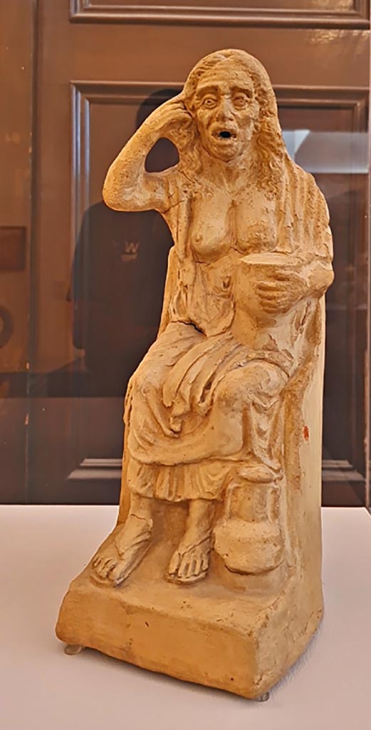 VI.15.5 Pompeii. October 2023.
Clay figurine of an old drunken woman. Photo courtesy of Giuseppe Ciaramella.
On display in “L’altra MANN” exhibition, October 2023, at Naples Archaeological Museum.