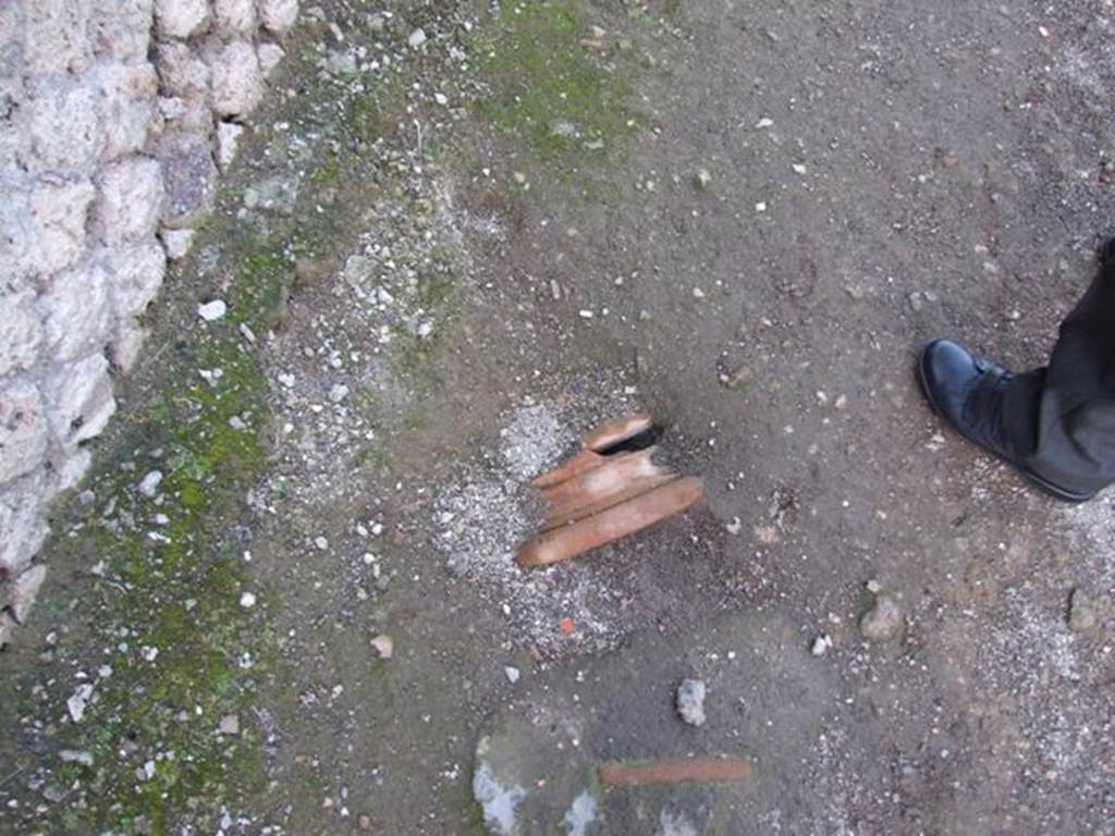 Pompeii. Terracotta pot or base buried in pavement between VI.15.6 and VI.15.7. December 2007.
