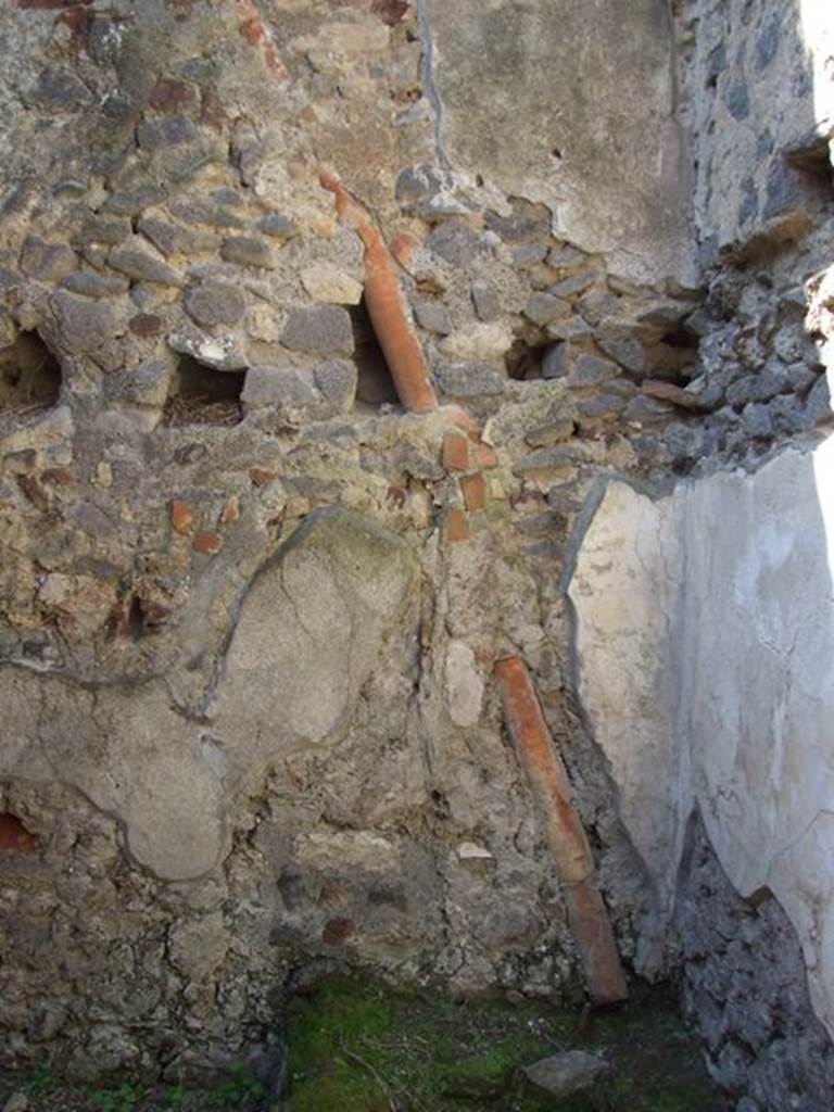VI.15.9 Pompeii. March 2009. Kitchen and Latrine. West wall, downpipe, and holes in wall for upper floor support.