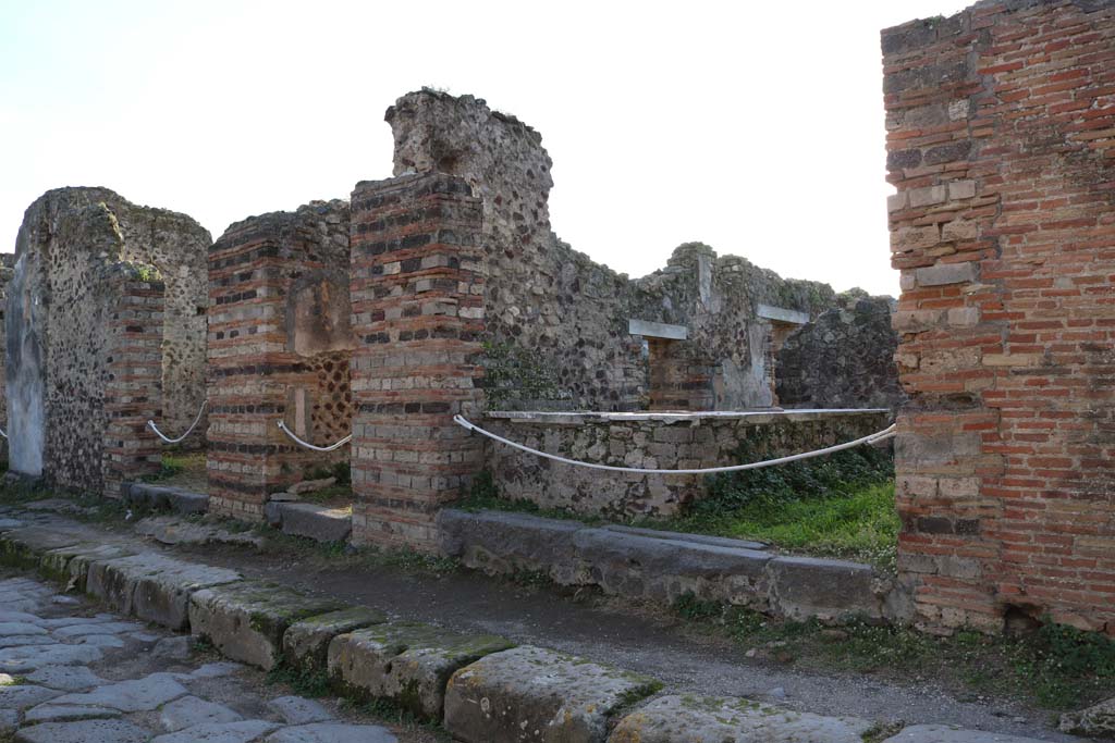 VI.15.15 Pompeii, on right. December 2018.
Looking south-east towards entrances on west side of Vicolo dei Vettii. Photo courtesy of Aude Durand.