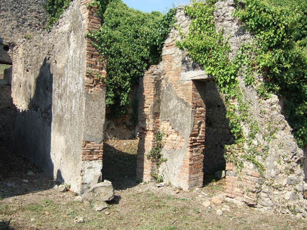 VI.15.20 Pompeii. September 2005. Looking north-east from atrium towards doorways to corridor to kitchen, left, and oecus, centre. According to Hobson, Reg. VI had two upper storey latrines that still had visible signs of the latrine above the ground floor level, these were in VI.15.20 and VI.15.22.  See Hobson, B., 2009. Latrinae et foricae: Toilets in the Roman World. London; Duckworth. (p.75)
According to Eschebach, the corridor on the north side of the atrium led to the kitchen and latrine which had a downpipe from the upper floor. See Eschebach, L., 1993. Geb�udeverzeichnis und Stadtplan der antiken Stadt Pompeji. K�ln: B�hlau. (p.223)

According to NdS, only the lower part of the walls of the oecus were faced with white plaster, partitioned by black lines. In the south wall was a small niche. See Notizie degli Scavi di Antichit�, June 1897, (p.275)

In the room to the north of the tablinum, the doorway on the right of this photo, a pile of lime prepared for work was found, together with some tiles. (p.274)


