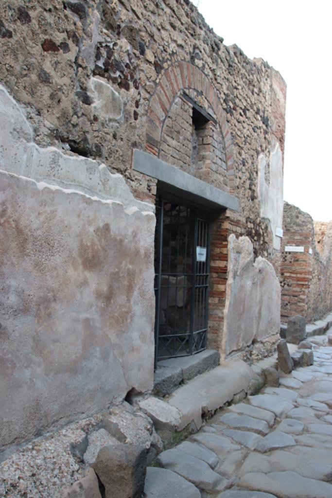 VI.15.27 Pompeii. October 2023.
Looking east towards entrance doorway on north side of Vicolo di Mercurio. Photo courtesy of Klaus Heese.